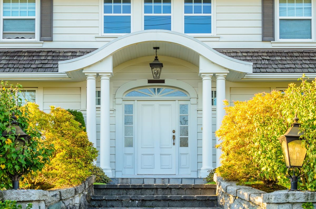 A nice entrance of a luxury house over outdoor landscape.